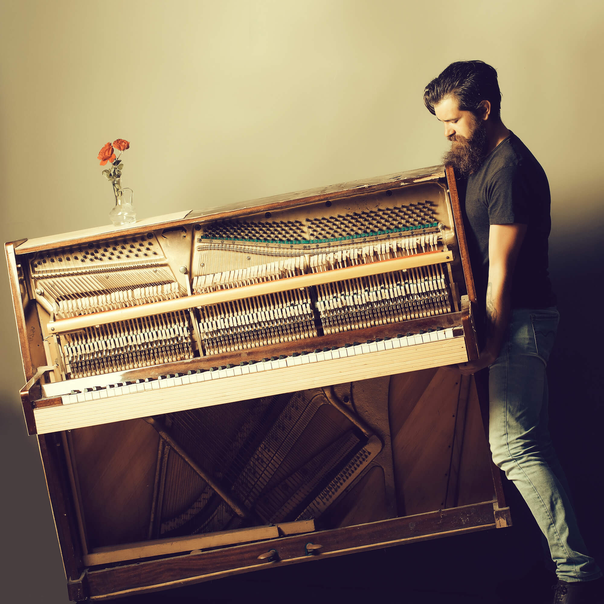 Man lifting wooden old piano